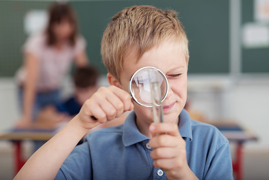 boy studying test tube of water